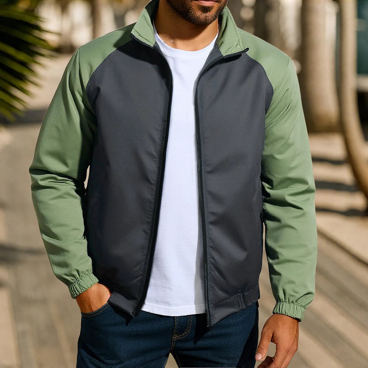 Man wearing a green loose-fit casual jacket with a stand collar and raglan long sleeves.