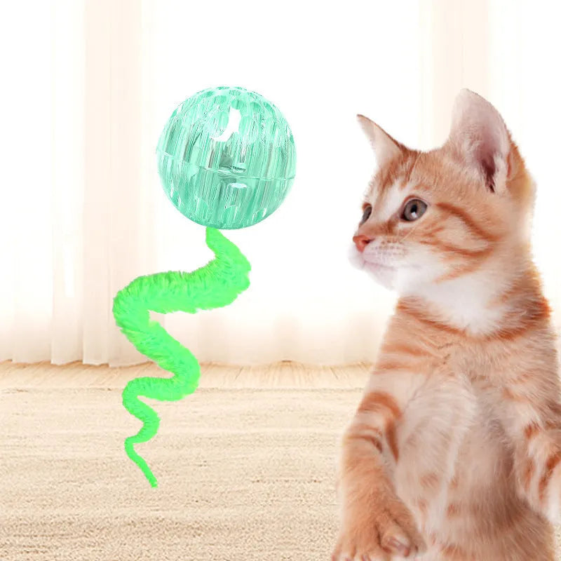 Green interactive cat toy with a bouncy ball and a long worm-shaped tail on a plain background.