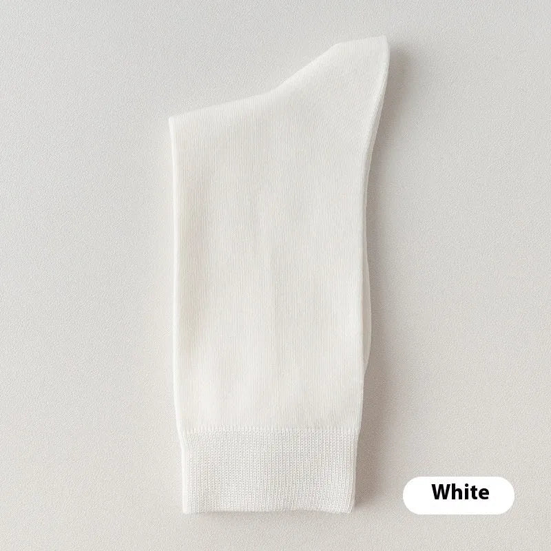 Pair of solid-colour men's mid-calf socks made from combed cotton on a wooden background