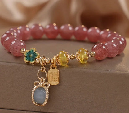 Red beaded bracelet with strawberry quartz gems, alloy clasp, and rhinestone details.