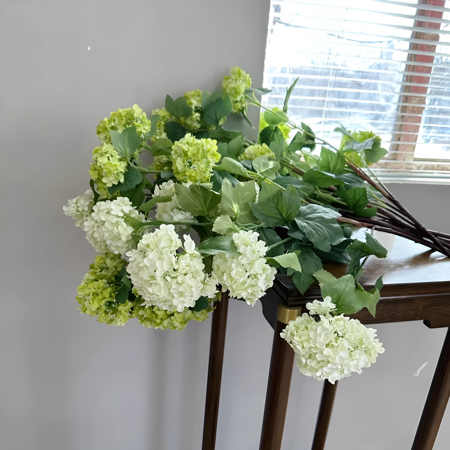 Artificial silk hydrangea flower on long stem branch in white or green colour