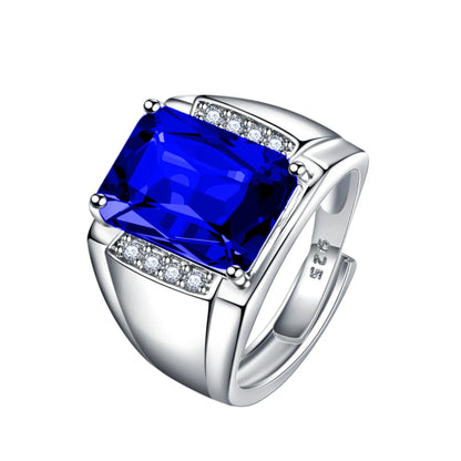 Adjustable copper ring with a geometric setting holding a blue rhinestone, shown on a finger.