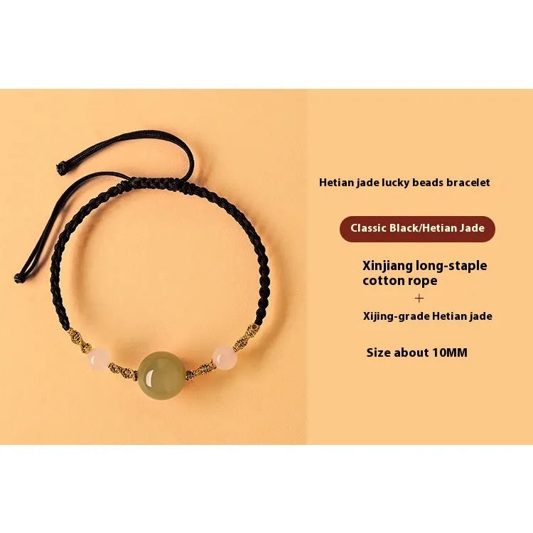 Hand-woven red rope bracelet with Hetian jade lucky beads on a wrist.