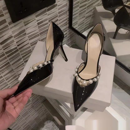 Women's black pointed toe patent leather stiletto high heels with pearl decoration on the upper.