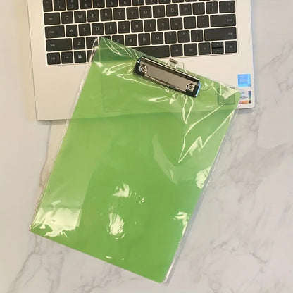Transparent A4 plastic plate holder with metal clip, holding white paper, on a desk.