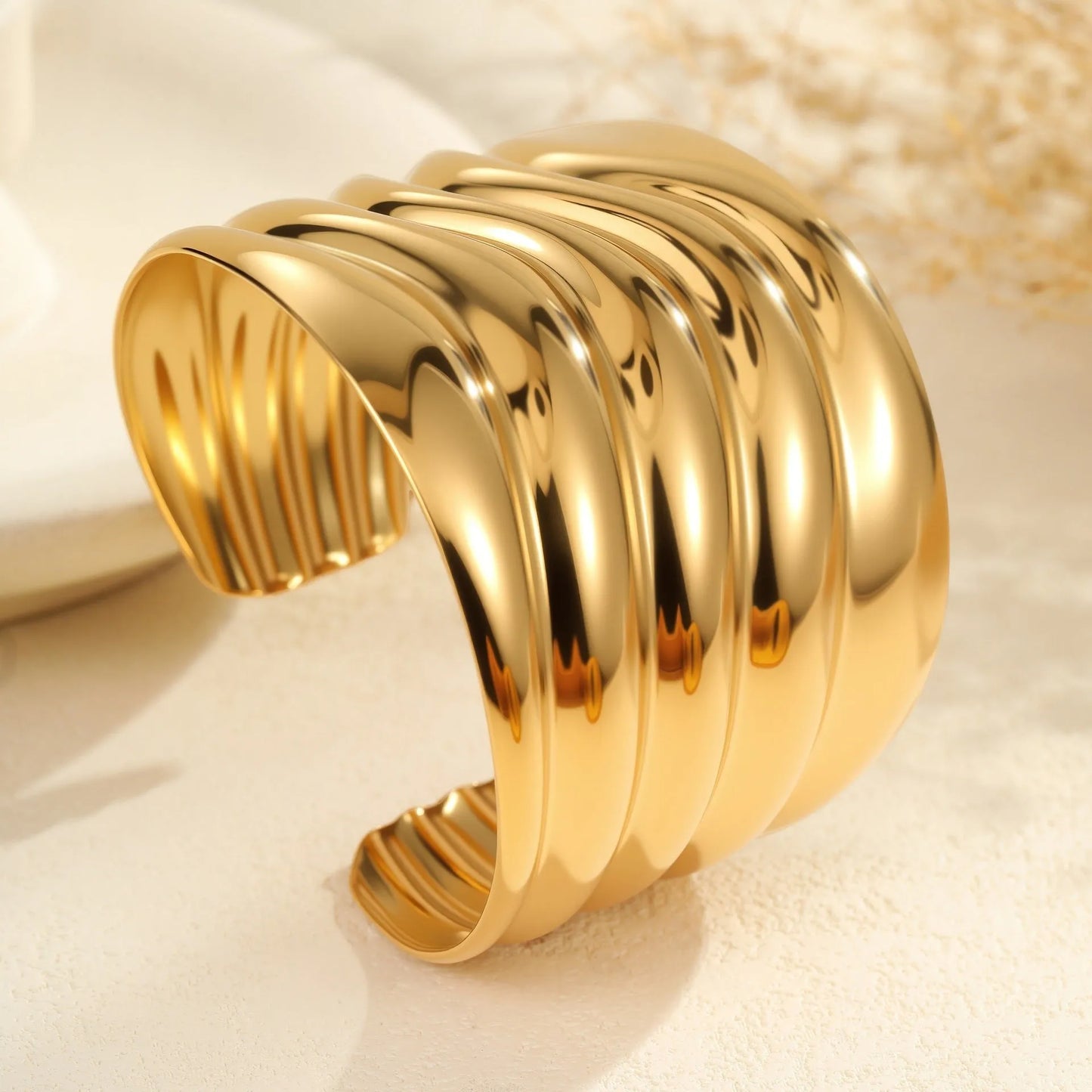 Women's stainless steel bracelet with 18K gold plating featuring exaggerated wide geometric wave design and niche opening