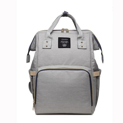Stylish maternity diaper bag in various colors, featuring a paper bag design, separate bottle compartment, and discreet breastfeeding button.