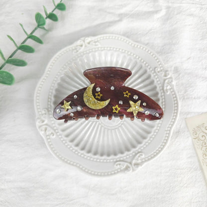 Oversized star barrettes in starry sky colours showing minimalist design and irregular elements
