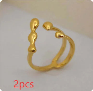 A minimalist brass ring with a small spherical detail on a plain band, shown in gold tone.