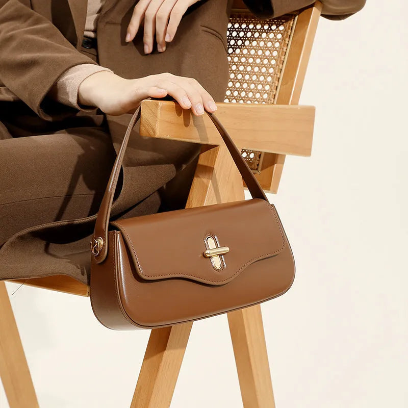 Genuine leather baguette handbag in horizontal square shape with clamshell opening and internal zip compartments