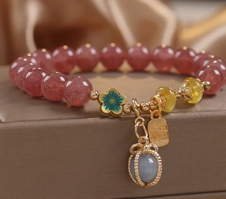 Red beaded bracelet with strawberry quartz gems, alloy clasp, and rhinestone details.