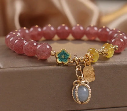 Red beaded bracelet with strawberry quartz gems, alloy clasp, and rhinestone details.