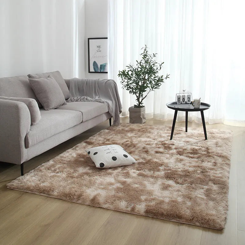 Soft fluffy plain rectangle carpet with anti-slip dots on backing, shown in a light grey colour on a wooden floor.
