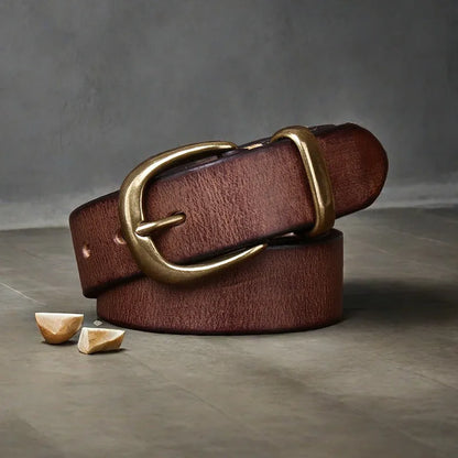 Men's black cattlehide leather jeans belt with a copper pin buckle shown on a flat surface.