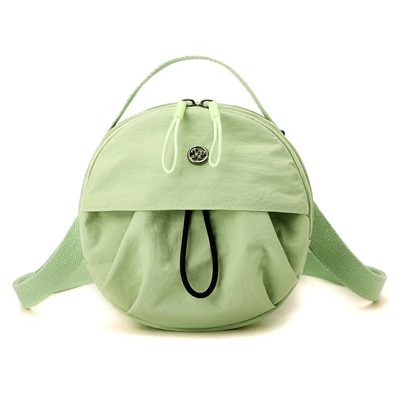 Out shoulder crossbody messenger bag in nylon showing interior zipped changing bag, phone pocket, and document compartment.