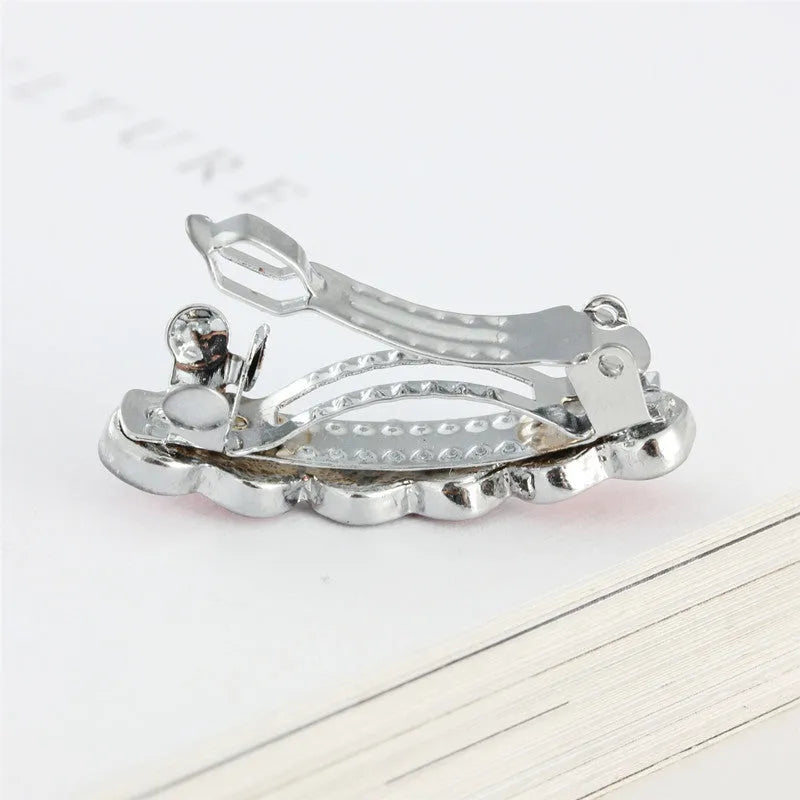 A 3cm long peach heart shaped hair clip with rhinestones and a small dog charm, on a white background.