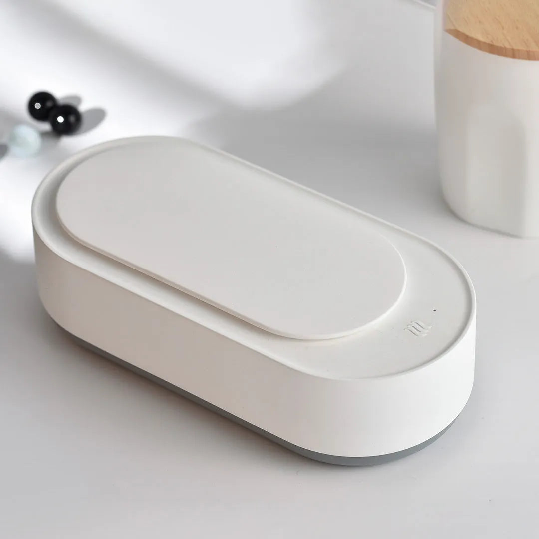 White portable ultrasonic cleaner with stainless steel tank for cleaning jewellery and glasses.