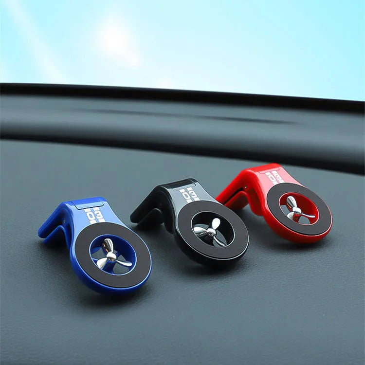 Black magnetic car phone holder attached to air vent with phone mounted and fragrance slice visible