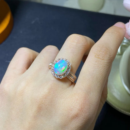 Handmade adjustable silver ring with a natural opal, shown in rose gold, yellow gold, and white gold plated finishes.