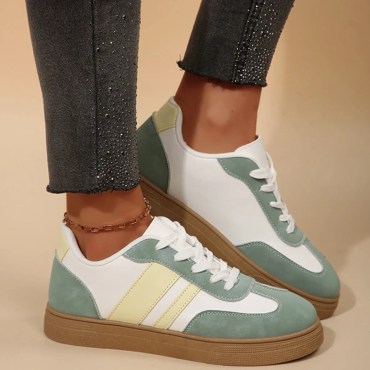 Women's green and white retro-style low-top casual pumps with cross straps and a flat rubber sole.