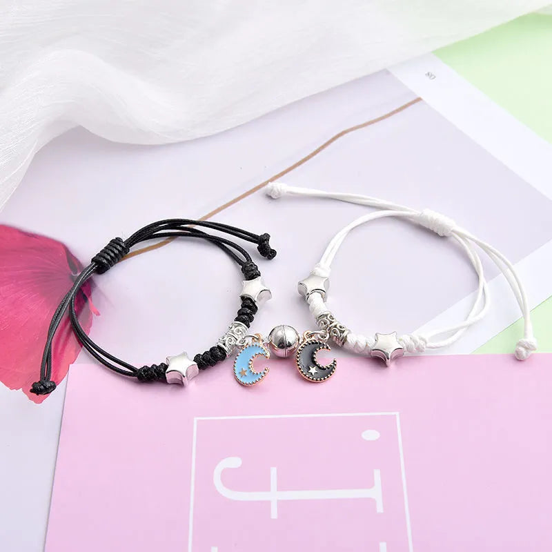 A pair of magnet couple bracelets with a suction clasp, showing various design options like clovers, crowns, and hearts.