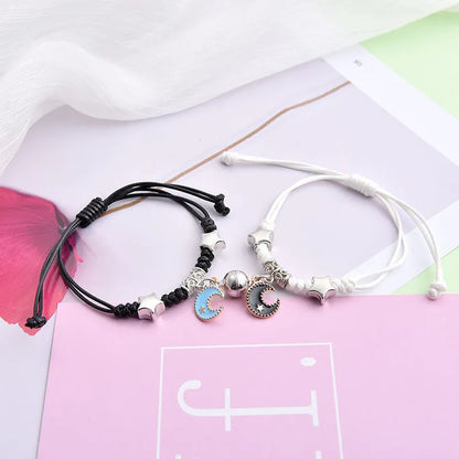 A pair of magnet couple bracelets with a suction clasp, showing various design options like clovers, crowns, and hearts.