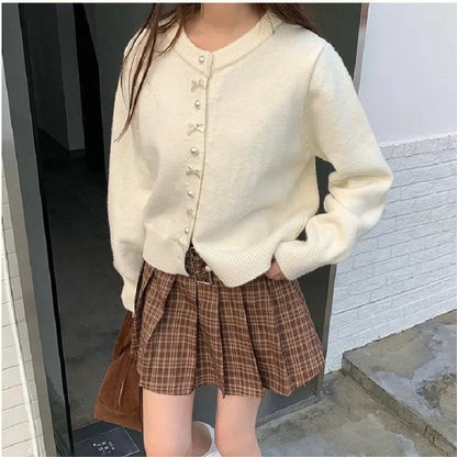 Women's acrylic cardigan sweater with pearl button bow detail in light yellow colour