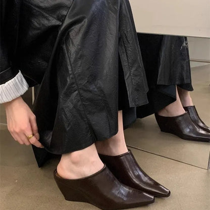 Women's black wind wedge closed toe half slippers showing PU upper and open back.