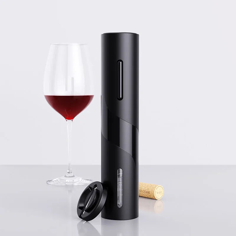 Black electric wine opener with transparent cover and aluminum foil cutter on wooden table