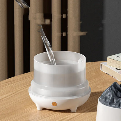 Volcano-shaped white ultrasonic humidifier with mist output on wooden surface