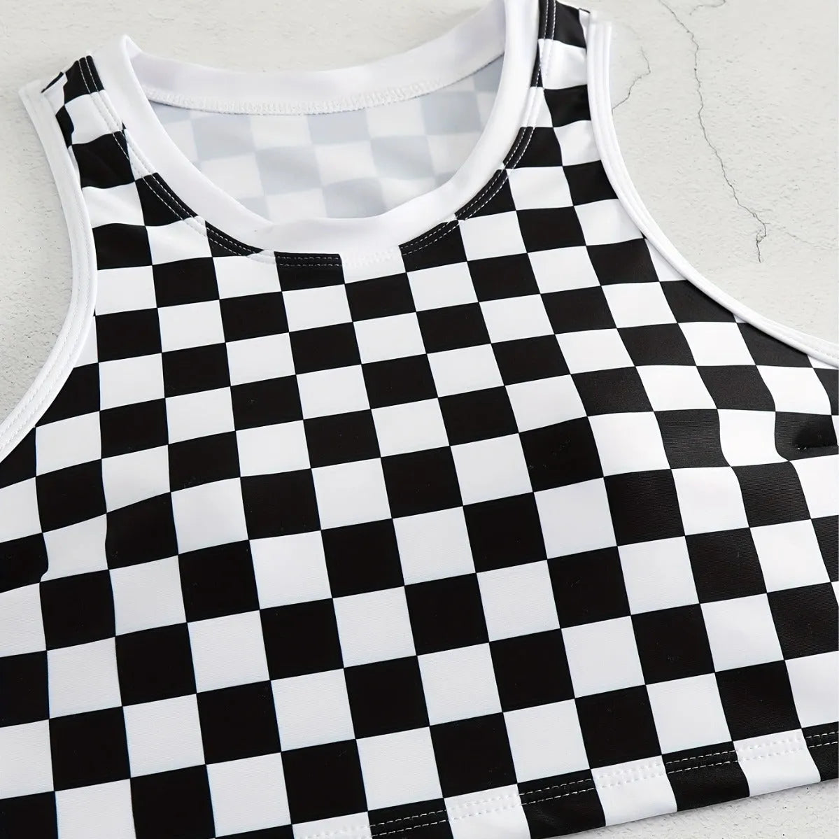 Women's checkerboard print backless one-piece swimsuit with suspender straps for swimming.