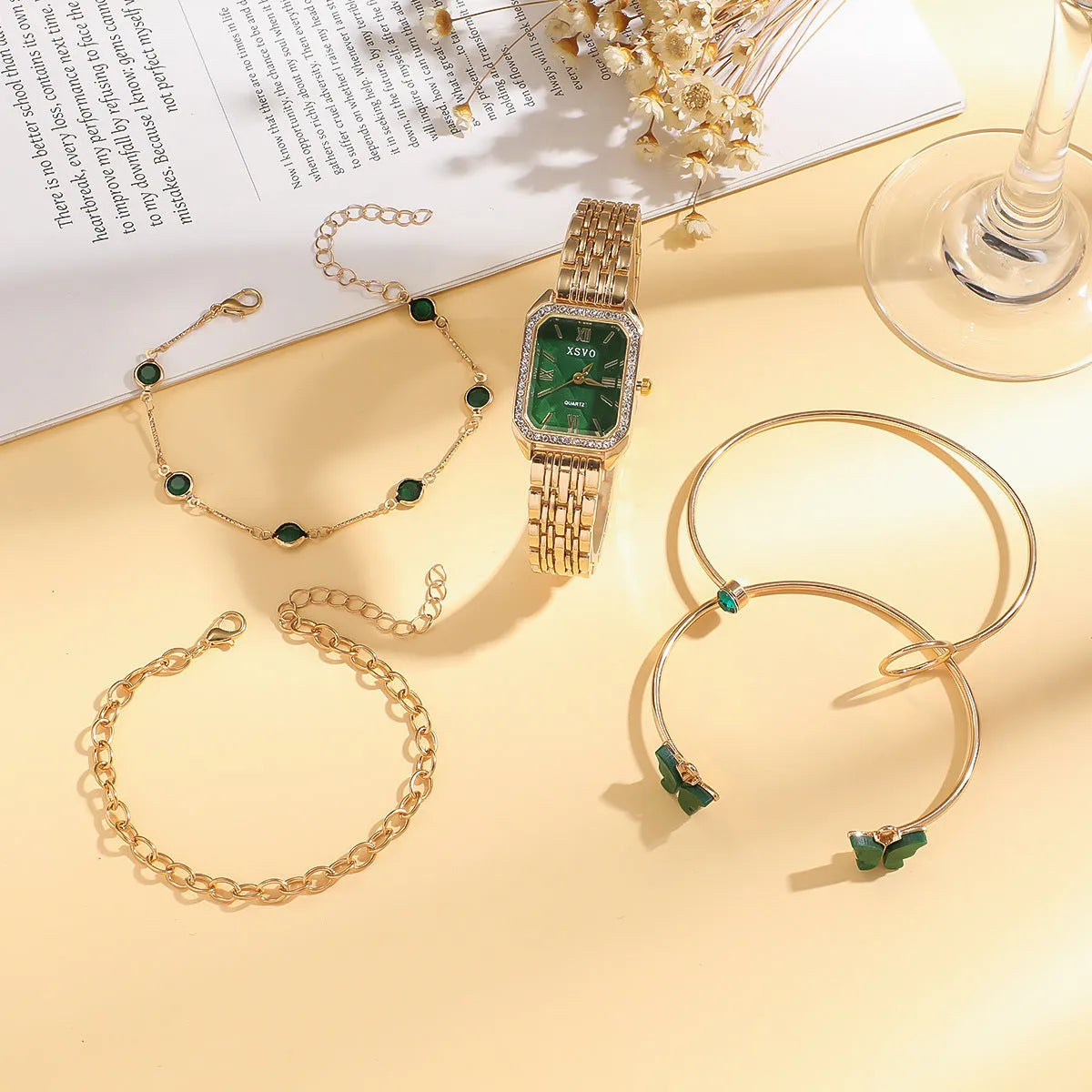 Gold green square women's watch with four matching butterfly bracelets on display