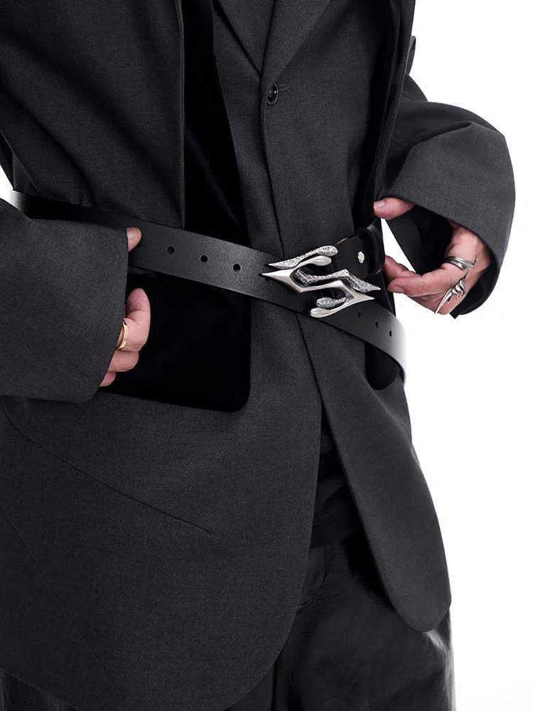 Men's black leather belt with a silver metal letter-design buckle on a flat surface.