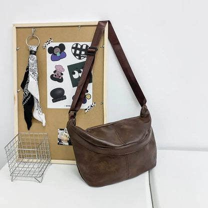 Men's brown vintage PU leather crossbody bag showing large main compartment and slim profile