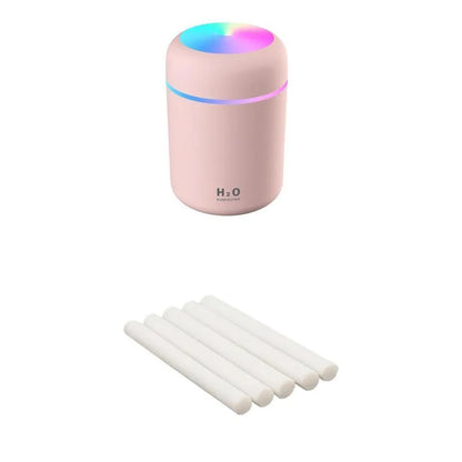 Pink USB desktop humidifier with LED lights and water tank on wooden desk