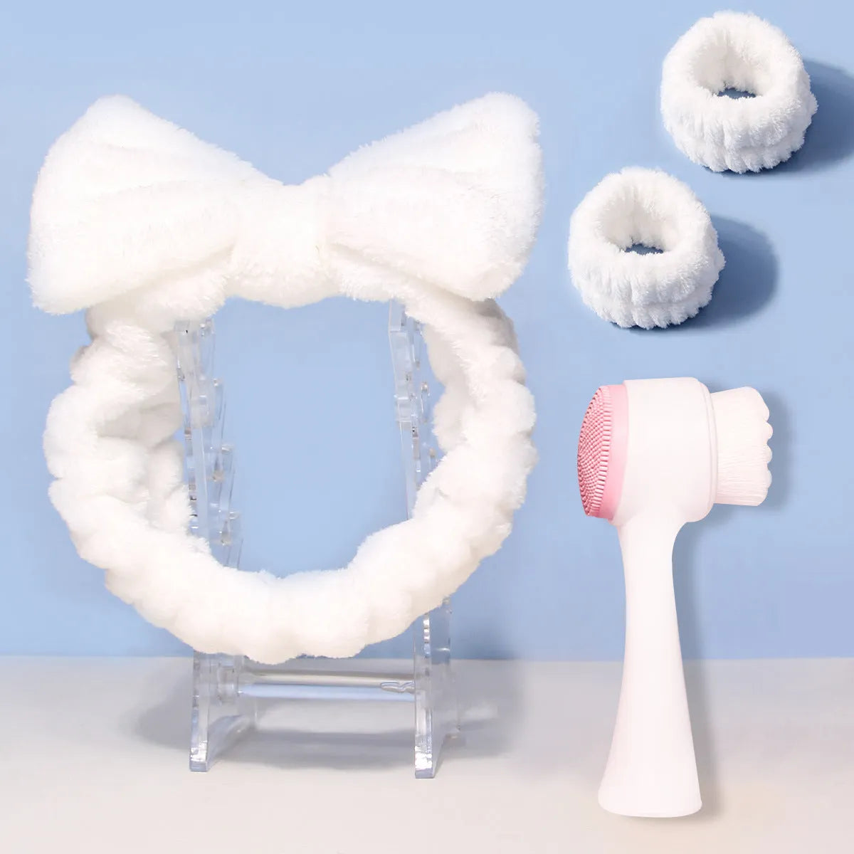 Facial brush set with coral fleece hair band and four nylon-bristle brushes in purple, grey, white, or pink colours