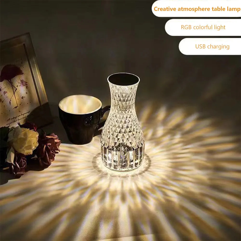 Vase-shaped crystal table lamp with remote control on a bedside table, showing diamond-like glow and USB charging port.