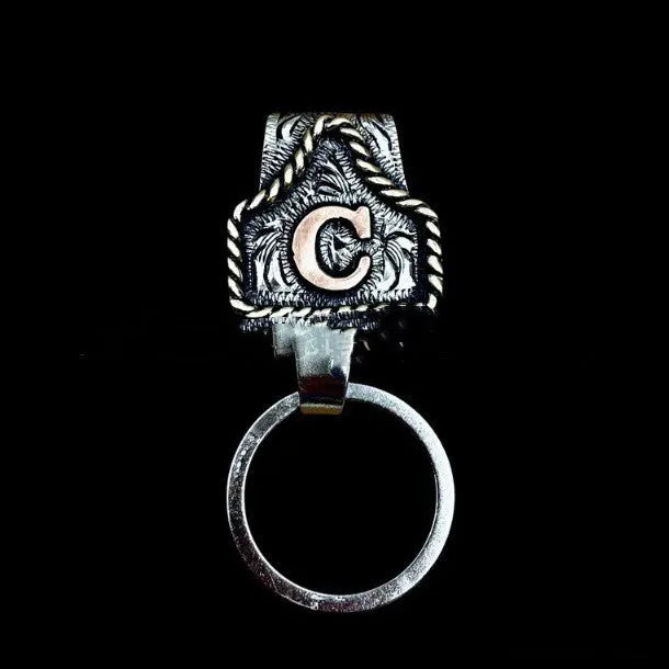 Handmade cow tag design metal keychain on a keyring, shown in one of many available colours.