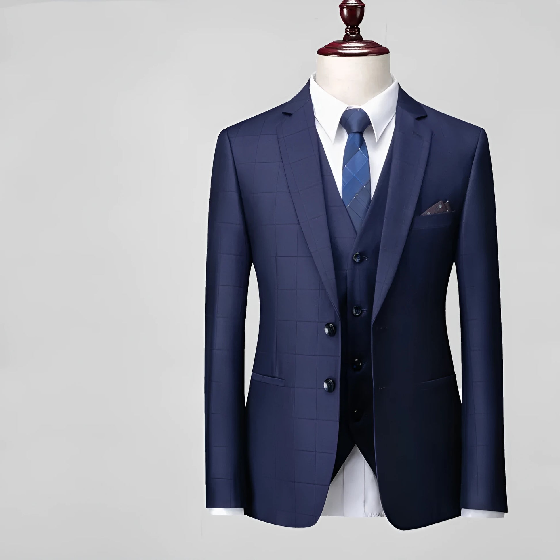 Man wearing a navy blue plaid slim-fit three-piece suit with jacket, waistcoat, and trousers