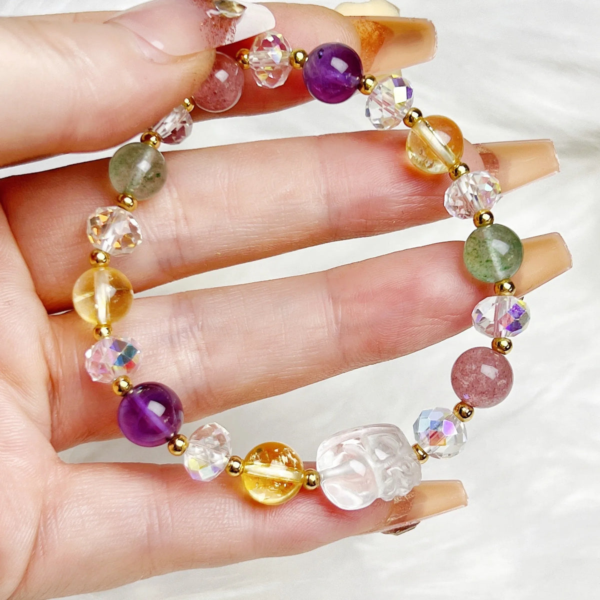 Close-up of a handmade crystal bracelet with a detailed nine-tailed fox design on a wrist.
