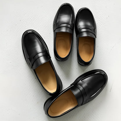 Classic black slip-on Derby leather shoes for men and women on a plain background