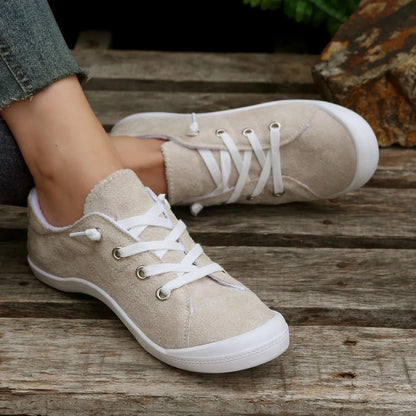Women's creamy white low-top casual sneaker with fabric upper and rubber sole.