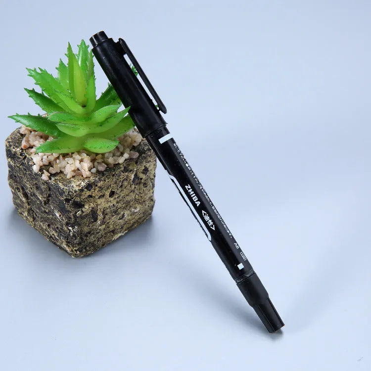 Diamond painting repair tool set with metal scraper pen, bottle of adhesive liquid, soft brush, and bamboo stick on a craft table