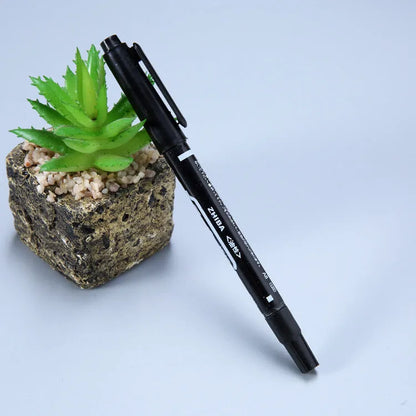 Diamond painting repair tool set with metal scraper pen, bottle of adhesive liquid, soft brush, and bamboo stick on a craft table
