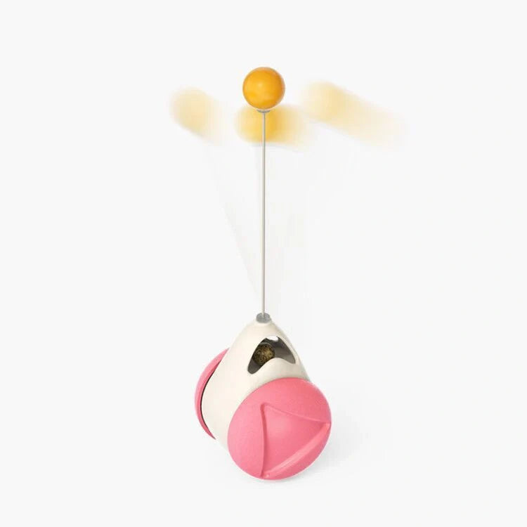 Cat playing with rotating windmill toy featuring luminous balls and suction base