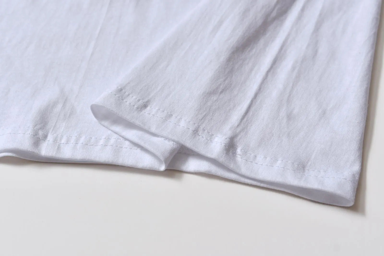 White cotton T-shirt style overalls with short sleeves and loose fit pullover design