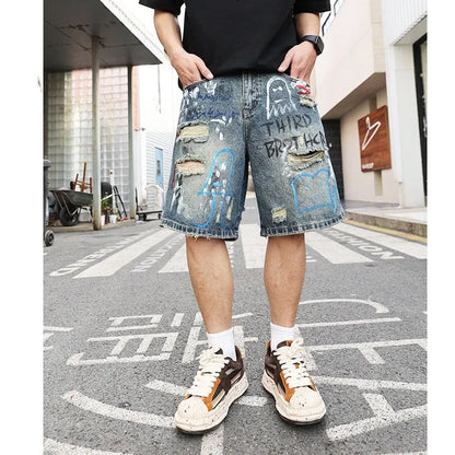 Blue men's jeans shorts with ripped distressed detailing and graffiti design, straight leg cut with zipper fly