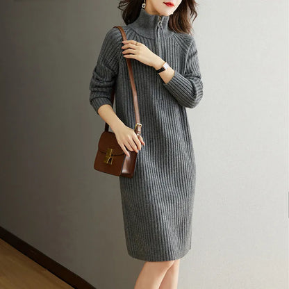 Beige half-zip woolen skirt with long sleeves, a stand collar, and a loose, straight midi silhouette.