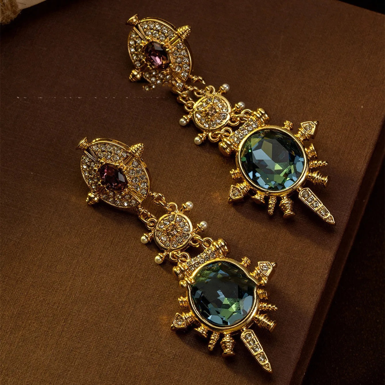 A pair of gold-coloured geometric stud earrings with round details and a retro style.