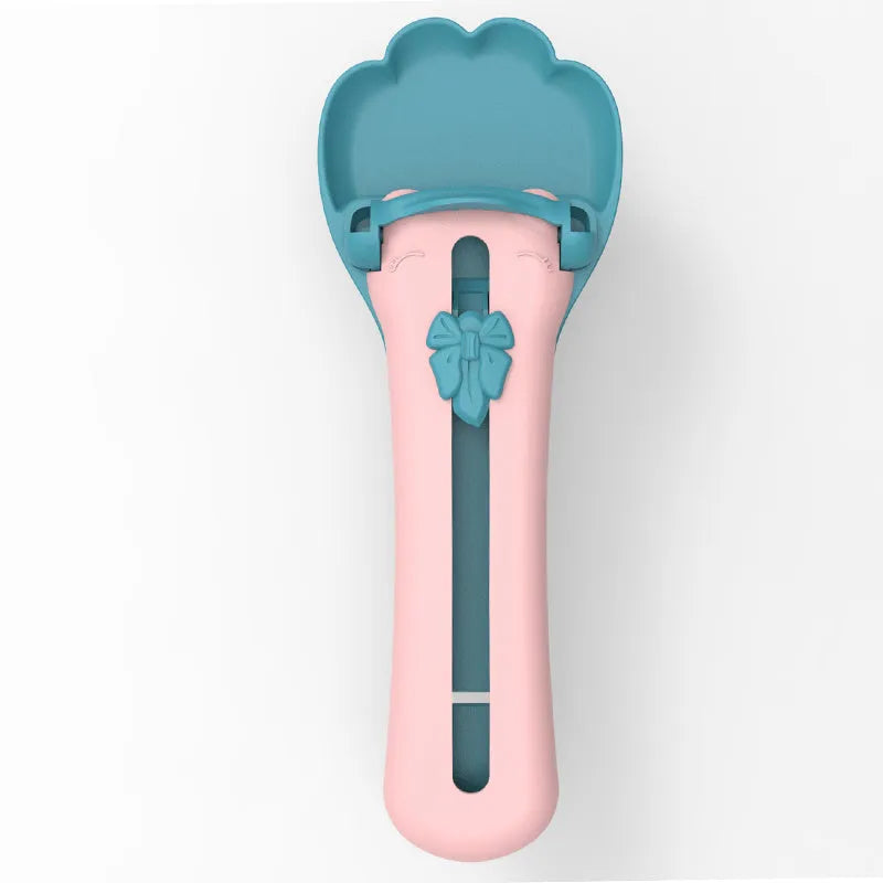 Green plastic pet food scoop with squeezer handle and dispensing nozzle for kibble and liquid.